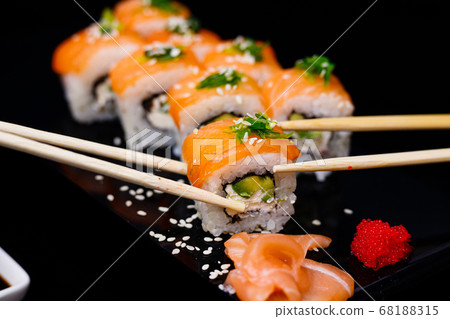 Sushi with salmon. Soy sauce, red caviar. Sushi on a black background. Sushi with salmon. Soy sauce, red caviar. Sushi on a black background. 68188315