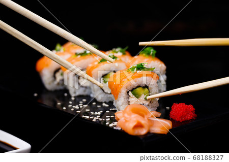 Sushi with salmon. Soy sauce, red caviar. Sushi on a black background. 68188327