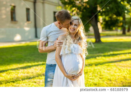 Happy young pregnant couple hugging in nature. 68188979