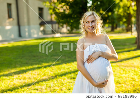 Portrait of a happy pregnant woman in a park 68188980