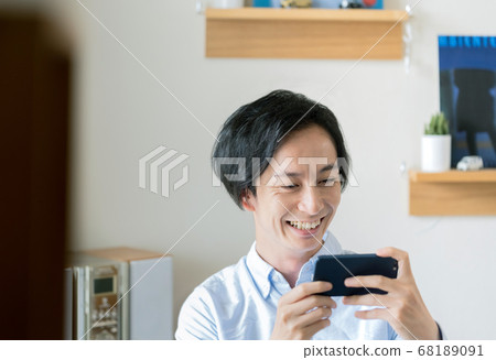 一名男子在智能手機上觀看視頻分發 一名男子在智能手機上觀看視頻分發 68189091