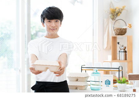 A man working as a cafe clerk [takeout] 68189275