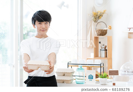 A man working as a cafe clerk [takeout] 68189276