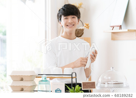 A man working as a cafe clerk [takeout] 68189282