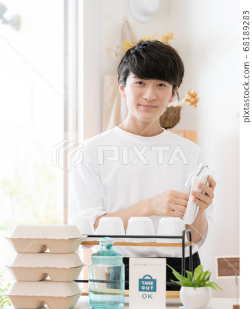 A man working as a cafe clerk [takeout] 68189283