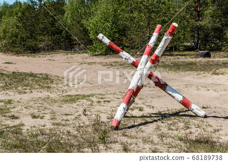 military fence with barbed wire blocks the road 68189738