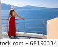 young woman enjoying view of Santorini, Greece 68190334