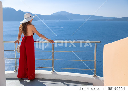 young woman enjoying view of Santorini, Greece 68190334