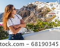 Happy smiling woman tourist traveling on luxury cruise in Mediterranean, Greece, Santorini. Female with folded arms, background architecture island sea sky 68190345