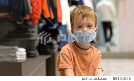Child in a protective mask in a store Child in a protective mask in a store 68191698
