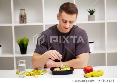 Shaped and healthy man holding a fresh meal bowl with meat 68193481