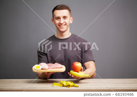Shaped and healthy man holding a fresh meal board with meat Shaped and healthy man holding a fresh meal board with meat 68193486