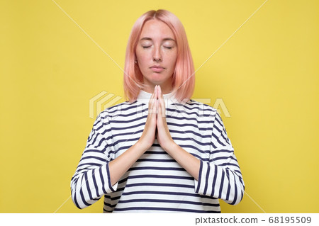 Beautiful casually dressed young woman praying Beautiful casually dressed young woman praying 68195509