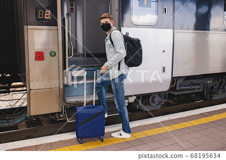 Man wearing protective face maskgoing to enter the intercity train. 68195634