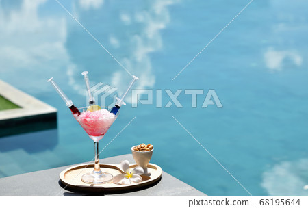 Drink a cocktail on vacation at the swimming pool 68195644