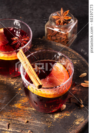 Mulled wine with slice of orange and spices on a wooden cutting board 68197173