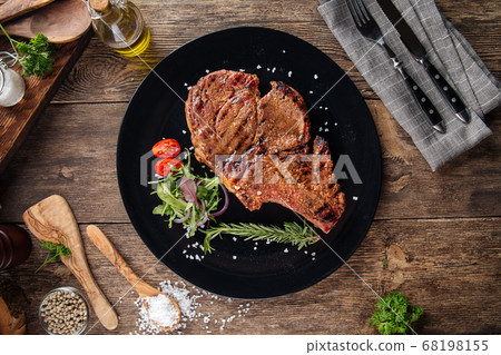 Top view on juicy cowboy steak on a black plate 68198155