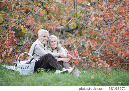 Portrait of elderly couple having a picnic in park Portrait of elderly couple having a picnic in park 68198371