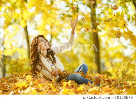 Beautiful young woman posing in autumn park 68198679