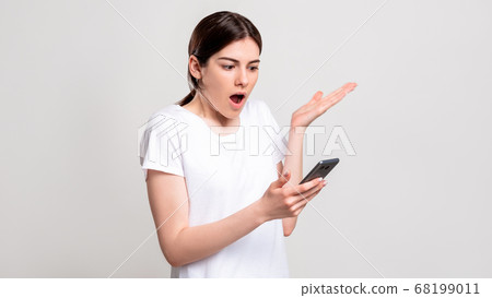 shocked woman portrait overwhelming news phone shocked woman portrait overwhelming news phone 68199011