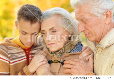 Portrait of sad grandfather, grandmother and grandson hugging 68199076