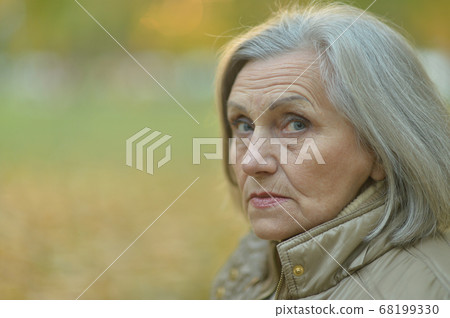 Portrait of sad, thoughtful senior woman in park Portrait of sad, thoughtful senior woman in park 68199330