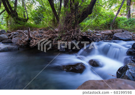 Pure water stream with smooth flow over rocky 68199598