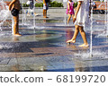 Children splashing in the city fountain. Hot summer day. 68199720