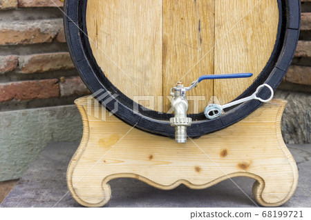 Wooden wine barrel with a tap. traditional concept of winemaking and wine tasting. 68199721