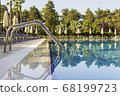 Sun beds by the pool in the open air. Pool at the spa resort. 68199723