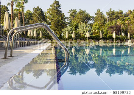 Sun beds by the pool in the open air. Pool at the spa resort. 68199723