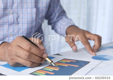 man hand analyzing financial diagram on office desk man hand analyzing financial diagram on office desk 68200410