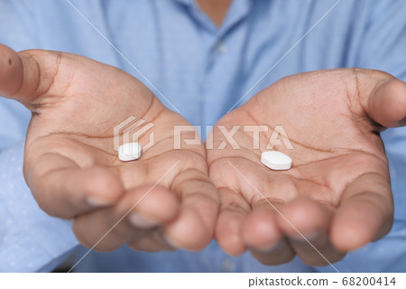Close up of white pills on palm of hand Close up of white pills on palm of hand 68200414