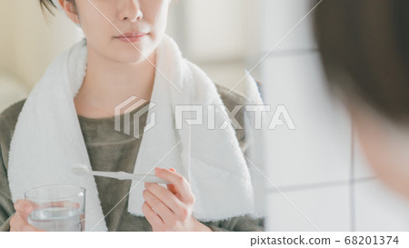 Woman in her 30s brushing teeth in the morning Woman in her 30s brushing teeth in the morning 68201374