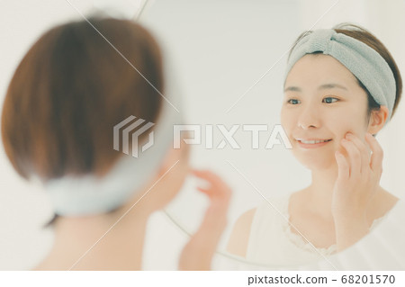 Woman in her 30s doing hairdressing with a hair band Woman in her 30s doing hairdressing with a hair band 68201570