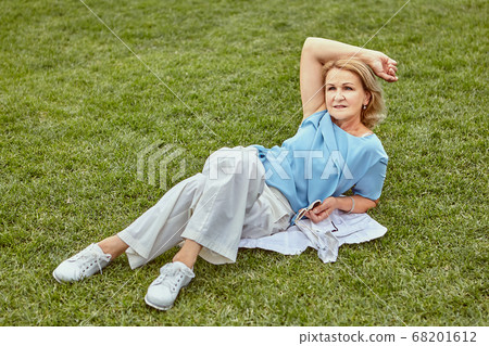 Aged pretty lady has rest outdoor. 68201612