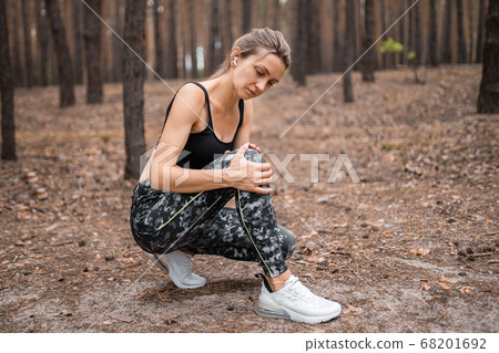 woman runner hold her sports injured knee 68201692