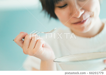 Arassa girls eating with a spoon 68201779