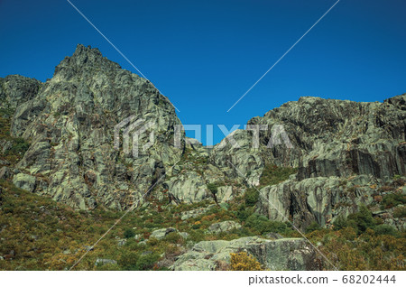 Landscape with rocky cliffs covered by green bushes Landscape with rocky cliffs covered by green bushes 68202444