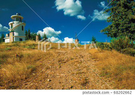 Rocky trail going to lighthouse on top of hill Rocky trail going to lighthouse on top of hill 68202662