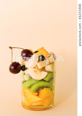 Summer fruit salad with banana, kiwi, peach, cherry, blackcurrent in glass Summer fruit salad with banana, kiwi, peach, cherry, blackcurrent in glass 68203806
