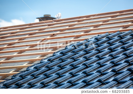 Black roof of burnt tiles under the construction, roof paver Black roof of burnt tiles under the construction, roof paver 68203885