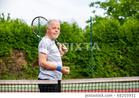 Portrait of happy senior man before his tennis match, sport concept Portrait of happy senior man before his tennis match, sport concept 68203931