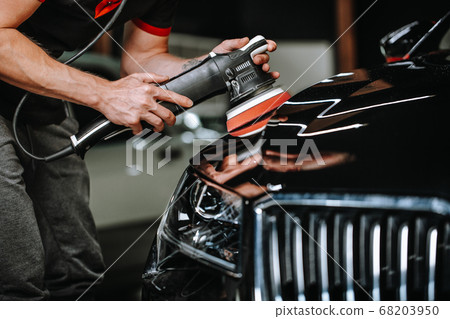 Professional detailing a car in car studio, hands with orbital polisher, scratching remover, vehicle care concept Professional detailing a car in car studio, hands with orbital polisher, scratching remover, vehicle care concept 68203950