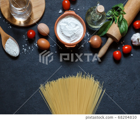 Dry spaghetti and products for cooking homemade pasta on a black background, top view Dry spaghetti and products for cooking homemade pasta on a black background, top view 68204810