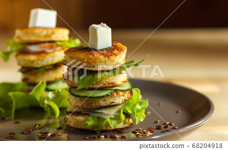 appetizer of mini pancakes, greens and soft cheese on a gray plate with flax seeds, with space, blurred background appetizer of mini pancakes, greens and soft cheese on a gray plate with flax seeds, with space, blurred background 68204918