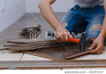 Man laying parquet flooring - closeup on male hands. worker joining parquet floor 68205457