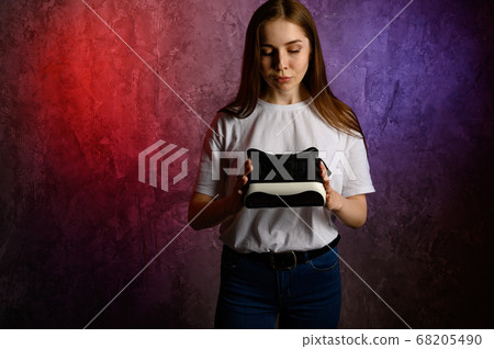 Happy young woman using a virtual reality headset 68205490