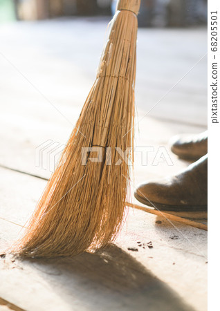man sweeps the wood floor. barn cleaning man sweeps the wood floor. barn cleaning 68205501