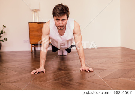 Muscular Athletic Fit Man is Doing Push Up Exercises at Home in His Bright Apartment with Minimalistic Interior 68205507